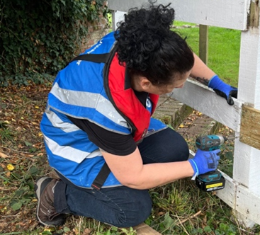 STERIS volunteer fixing a fence